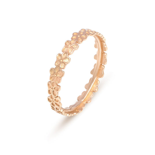 A rose gold Blossom ring by Elin Mair featuring a continuous pattern of small, openwork flowers, shown on a clean white background with a soft shadow.